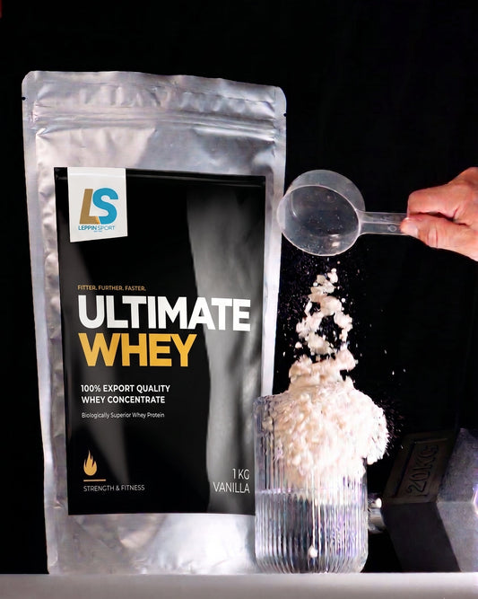 A silver stand-up pouch of LS Pro 4 Bulk four-tiered protein mix is shown on a black background, with a hand holding a scoop pouring white powder into a clear glass container.